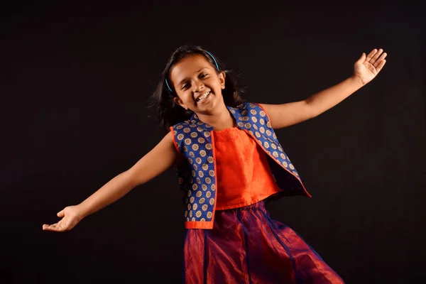 Malá holčička v indické oblečení s roztomilý úsměv a otevřenou náručí pózuje před kamerou. Pune, Maharashtra — Stock fotografie