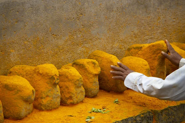 Man raakt saffraan gekleurde stenen, Maharashtra, India. — Stockfoto