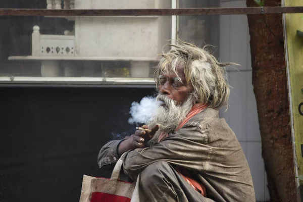 MAHARASHTRA, INDIA, March 2018, Beggar smoking with thick smoke. — Stock Photo, Image