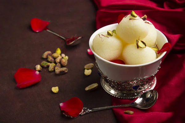 Ciotola piena di Rasgulla e pistacchi, un tavolo da pranzo, Pune, India . — Foto Stock