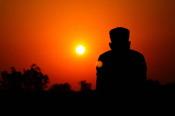 Menschliche Silhouette beobachtet die untergehende Sonne, Satara, Maharashtra, Indien. — Stockfoto