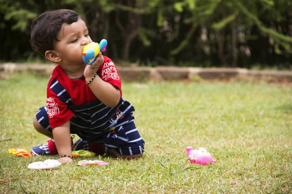 Lindo niño indio jugando con sus juguetes dentro de un jardín, Pune, Maharashtra . — Foto de Stock