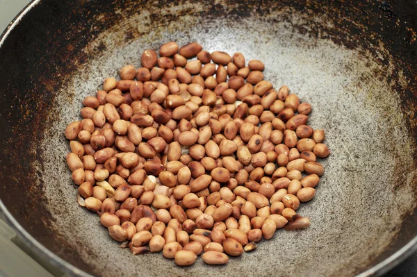 Roasting peanut in a frying pan, Maharashtra, India. — Stock Photo, Image