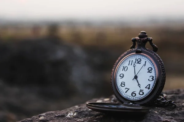 Quartz pocket analog watch kept on a rock