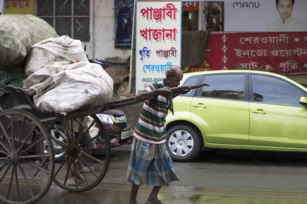 Kolkata, indien, august 2017, alter mann zieht eine ricksäge oder einen handgezogenen karren auf einer straße. — Stockfoto