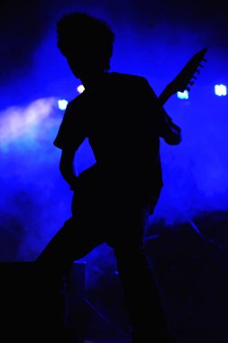 Bir konser, Hindistan mavi arka plan ile rock gitarist siluet