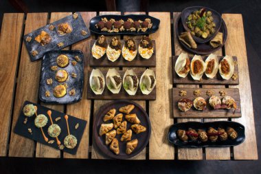 Atıştırmalık ya da aperatiflerin üst görüntüsü, içeceklerle birlikte yenecek tapas.