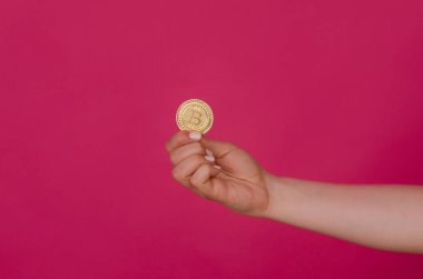 Bitcoin para pembe arka plan izole kadın elinde. El bitcoin madeni para ile. Cryptocurrency altın bitcoin para tutan el