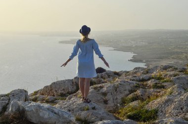 Dağda ayakta ve denizde seyir turist kadın. Yolculuk tutkusu seyahat kavramı, metin, alan atmosferik epik an. Cape Greco, Kıbrıs, Akdeniz