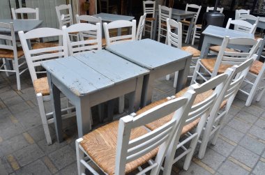 Ahşap masa ve sandalye kafe, yaz terası. Eski ahşap antika masa ve sandalyeler ile Kıbrıs'ta hasır koltuk gri. İç yaz Cafe.