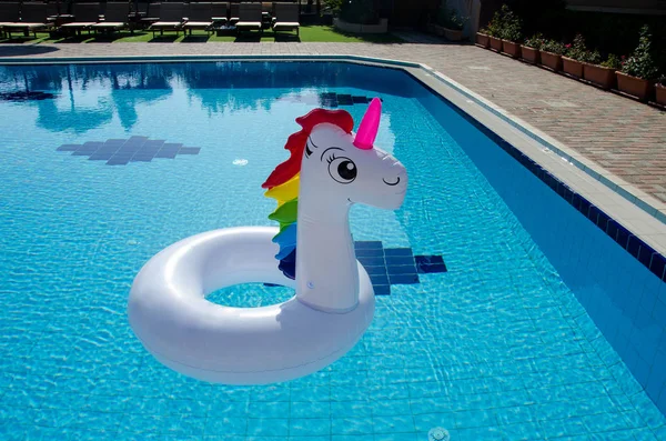 Unicorn pool float in blue water background, inflatable swim tube. Unicorn float, unicorn inflatable pool float.