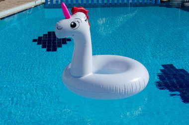 Şişme tek boynuzlu at. Tek boynuzlu at çocuk ve yetişkin şişme float. Tek boynuzlu at tüp ışık mavi su havuzu arka planda üzerinde yüzmek. 