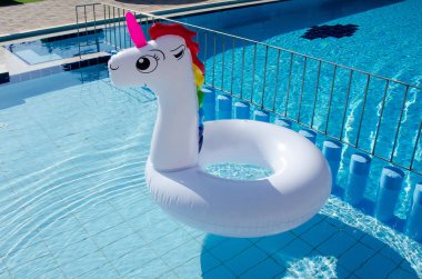 Tek boynuzlu at çocuk ve yetişkin havuzu mavi su ile şişme float. Yaz tatili, tatil plaj. Fantezi yüzerek yüzük. 