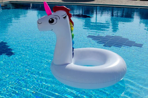 Unicorn pool float in blue water background. Unicorn inflatable float for kids and adult.