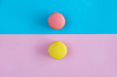 Bademli kurabiye, sarı ve yeşil macaron mavi ve pembe arka plan üzerinde. Copyplace, metin için yer.