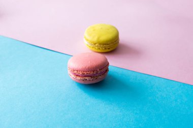 Mavi ve pembe arka plan üzerinde pembe macaron, yakın çekim. Seçici odak