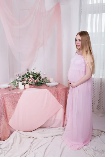 Gravid Kvinna Som Står Nära Bord Med Blommor Och Fönster — Stockfoto