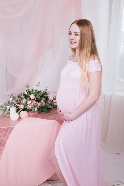 Gravid Kvinna Med Händerna Över Magen Med Blommor Bakgrunden — Stockfoto