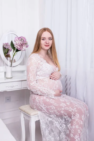 Tuvalet masasının oturan hamile kadın 