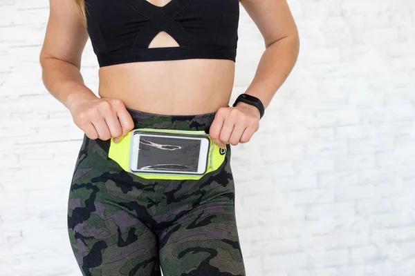 Close up of fitness woman with belt pouch for mobile phone. Sport woman with waist bag