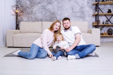 Anne ve baba evde kızlarıyla oynuyorlar. Evin içinde mutlu bir yaşam tarzı.