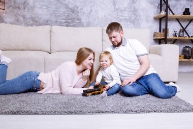 Küçük çocuklu bir aile tahta oyuncak lokomotifle oynuyor, tren.