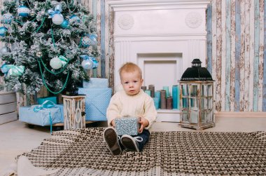 Noel hediyelerini tutan çocuk. Mutlu çocuk Noel tre oynarken