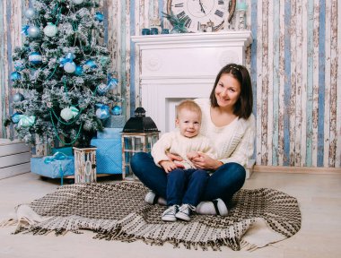 Mutlu anne ve oğlu Noel için dekore edilmiş ev. Anne ve küçük çocuk evde. Noel, yeni yıl, tatiller ve kış mevsim kavramı. Aile.