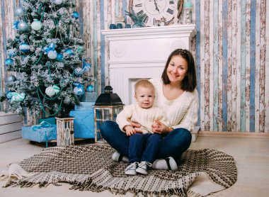Mutlu aile anne ve bebek Noel tatili küçük oğlum evde. Yılbaşı tatil. Toddler anne Noel ağacı ile festively bir şekilde dekore edilmiş oda ile. Anne ve bebek çocuk portresi