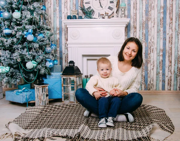 幸せな家庭 母と小さな男の子の手にギフト ボックスとクリスマス ツリーのそばに座って — ストック写真