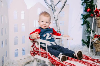 Çocuk atlı kızak üzerinde. Ahşap bir şekilde dekore edilmiş kızak kış iç oturan çocuk. Merry Christmas ve yeni Evet kavramı