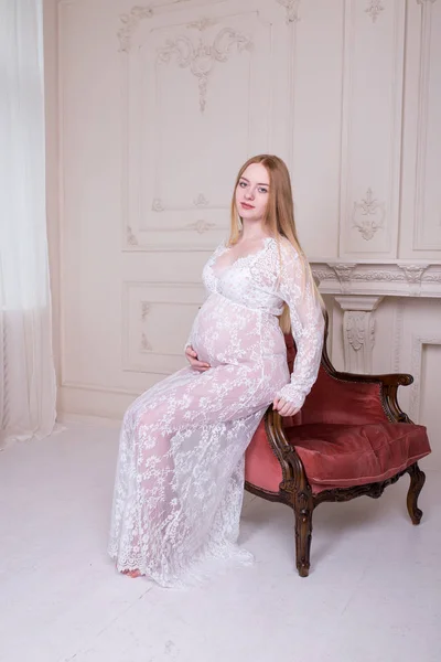 Gravid Kvinna Med Henne Händerna Över Magen Sitter Fåtölj Moderskap — Stockfoto