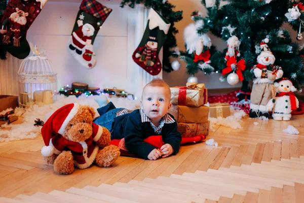 暖炉とクリスマス ツリーの近く自宅の小さな男の子 — ストック写真