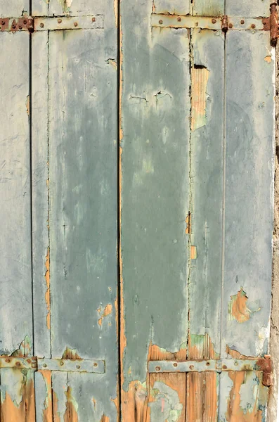 Old wooden door with leaving paint. Cracked paint on old wooden door. Texture, background. Weathered wood