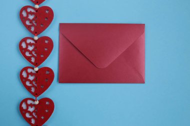 Mavi arka plan üzerinde kırmızı zarf ve kalpleri dekorasyon. Sevgililer günü kalpleri ile arka plan. Copyplace, metin ve logo için alan. 