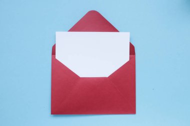 Mavi arka plan üzerine açık kırmızı zarf boş beyaz hediye kartı. Copyplace, metin ve logo için alan.