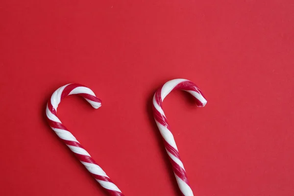 Christmas candy cane isolated on red background. Copyplace, space for text and logo.