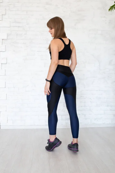 Sportive woman wearing black leggings and top sitting on chair Stock Photo