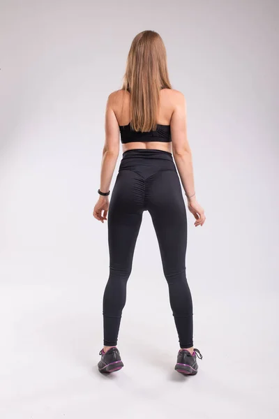 Vista posteriore della donna sportiva che indossa leggings sexy neri e top . — Foto Stock