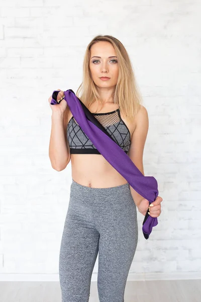Sportovní žena s fialový ručník. Fitness koncept — Stock fotografie