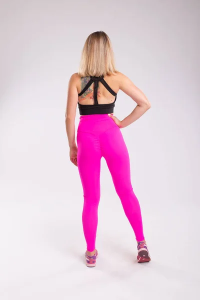 Visão traseira da mulher esportiva sentada vestindo leggings sexy e para — Fotografia de Stock