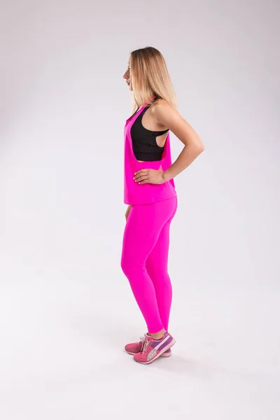 Side view of sporty woman in sport style clothes isolated on whi — Stock Photo, Image