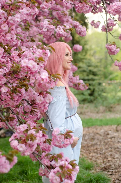 Щаслива вагітна жінка в синій сукні з рожевим волоссям — стокове фото
