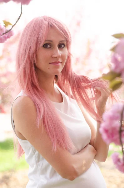 Hermoso vestido de mujer embarazada con flores de color rosa en el fondo —  Fotos de Stock