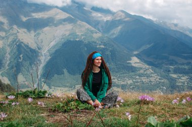 Svaneti dağda oturan dreadlocks ile Hipster kadın 