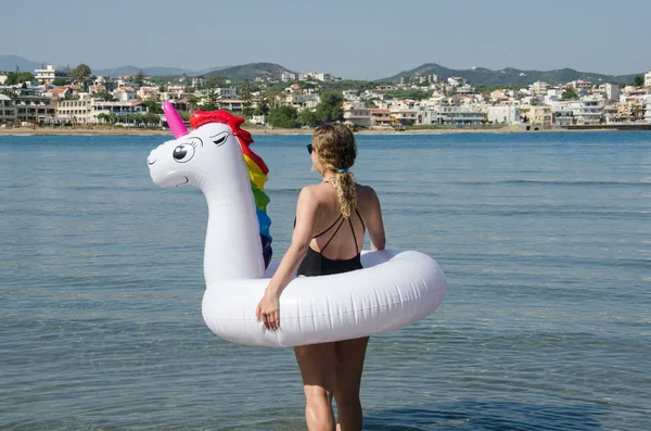 Flotador inflable del tubo del unicornio y mujer en el mar con Chania C — Foto de Stock