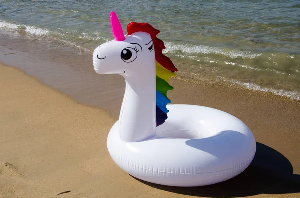 Unicornio piscina tubo en la playa. Flotador inflable del unicornio en — Foto de Stock