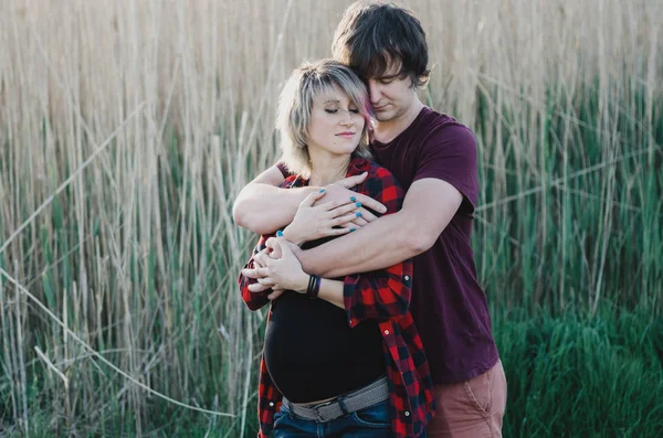 Mujer embarazada feliz y su marido en la naturaleza — Foto de Stock