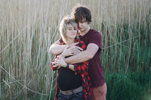 Una pareja feliz. Marido y su esposa embarazada relajándose en la naturaleza — Foto de Stock