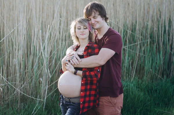 Concepto de embarazo y personas - hombre feliz abrazando a su embarazada wi — Foto de Stock